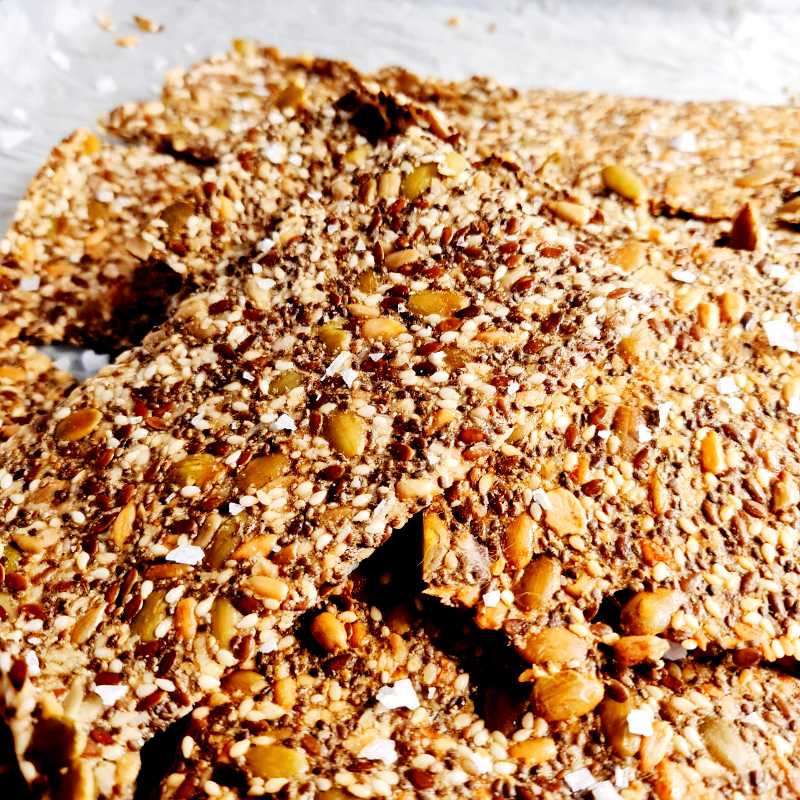 Handlingslista för dig som är ny på LCHF – så handlar du smart från början 8 En hög av fröknäcke med olika frön och nötter på en vit yta.