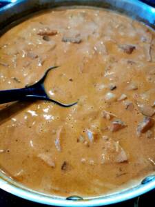 En panna med korv stroganoff som innehåller korvbitar i en krämig sås.