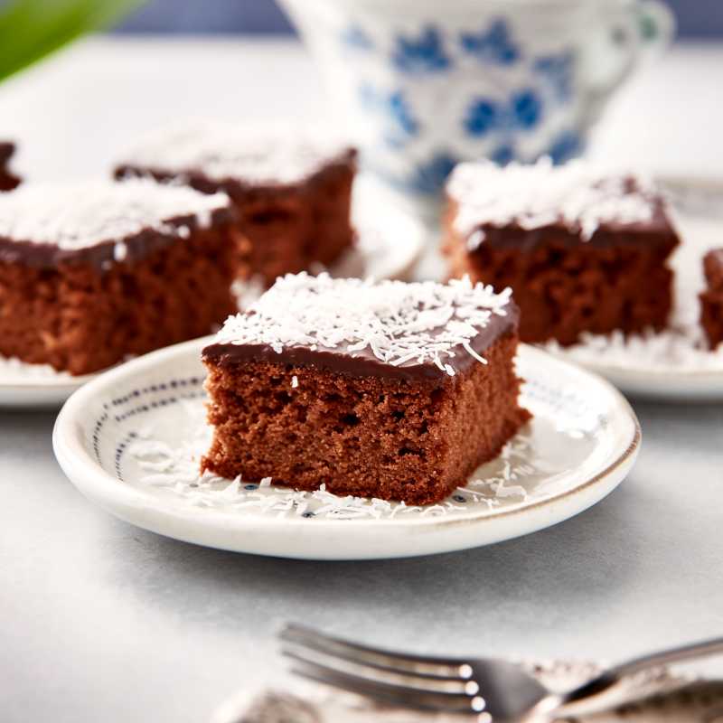 Rulltårta med hallon 8 En bit kärleksmums med chokladglasyr och kokosflingor på en tallrik.