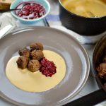 En tallrik med köttbullar serverade med sås och lingonsylt.