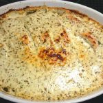 Ugnsbakad lax med parmesan och örter i en vit ugnsform.