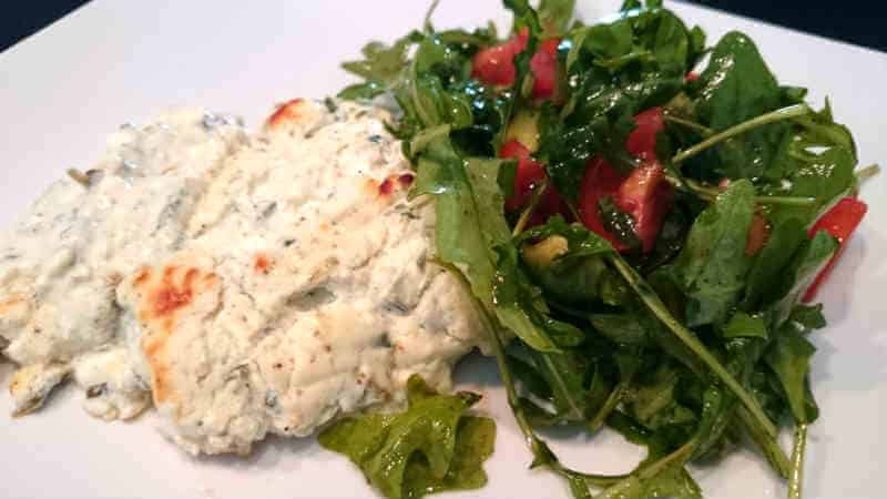 Mandelpanerad torsk 7 En portion fetaost och purjobakad torsk serverad med en grönsallad bestående av ruccola och tomater.