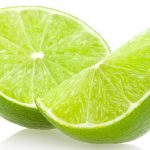 Halverad grön limefrukt med saftiga inre segment synliga.