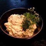 Skål med avokado- och jalapenoröra dekorerad med färska örter.