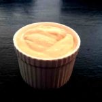En liten vit skål med hemgjord aioli på en mörk yta.
