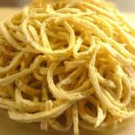 En hög av LCHF-pasta med en ljusgul färg på en skärbräda.