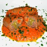 Oxrullader fyllda med grönsaker i en gräddig tomatsås, garnerad med hackad persilja.