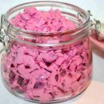 En glasburk fylld med rosa godisbitar i form av stjärnor.