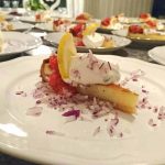 Västerbottensostpaj med röra och citron på en tallrik, omgiven av hackad lök.