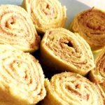 Rullade bakverk med kanel och socker, skurna i skivor och placerade på en tallrik.