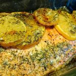 Ugnsstekt laxfilé med skivor av citron och dill ovanpå.