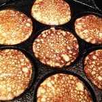 Kokosplattor som steks i en svart gjutjärnspanna med åtta fack.