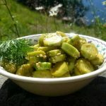 Skål med vitlöksmarinerad gurka och rostade sesamfrön, dekorerad med dill.