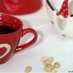 Röd kopp med hjärta fylld med kaffe och en vit kaffekanna med röd näbb.
