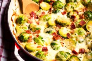 En gratinerad rätt med brysselkål och bacon i en ugnsform.