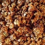 En närbild av granola med nötter, frön och en gyllene färgton.