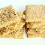 Staplade solrosfrö kex med en gyllene yta på en vit tallrik.