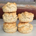 Fem scones staplade i en pyramidform på en yta med ljus bakgrund.
