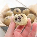 En hand som håller en kakaoboll med chokladbitar, med fler bollar i bakgrunden.