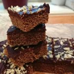 Tre bitar av pepparkaksmums med chokladtopping staplade på varandra.
