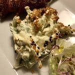 En portion kål- och sesamsallad med krämig sås på en tallrik.