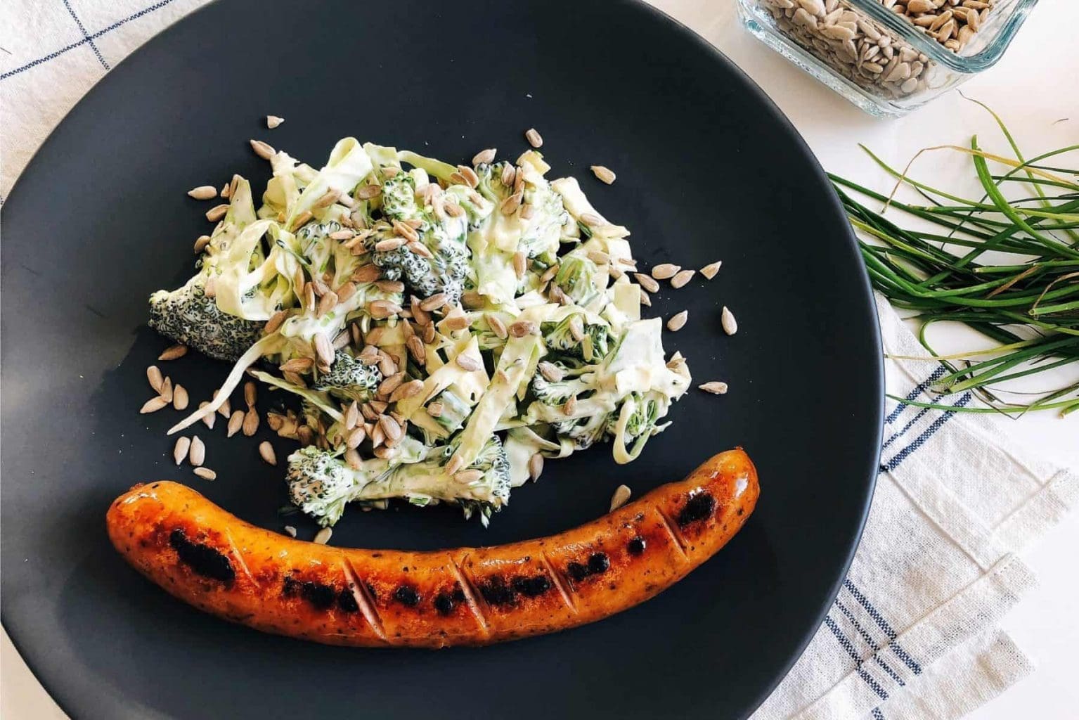 Picklad rödlök (utan socker) 16 En tallrik med grillad korv och en broccolisallad med solrosfrön.