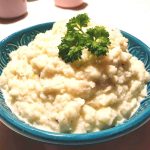 Vitkålsmos serverat i en blå skål med en grön persiljekvist på toppen.