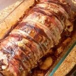Köttfärslimpa inlindad i bacon i en glasform, tillagad och gyllenbrun.