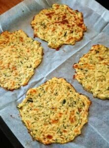 Fyra zucchinibaserade plattor på ett bakplåtspapper.