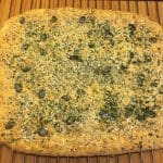Kryddat bröd med frön och örter på en träyta.