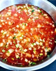 Salsa med jalapeños, tomater, lök och koriander i en metallskål.
