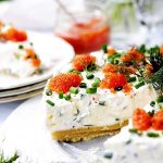 Midsommar cheesecake med gräddfil, laxrom och gräslök på en tallrik.