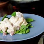 En tallrik med kycklingsallad som ligger på spenatblad.