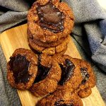 En hög av kakor med chokladfyllning på en träskärbräda.
