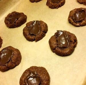 Kakor med chokladfyllning placerade på en bakplåt med bakpapper.
