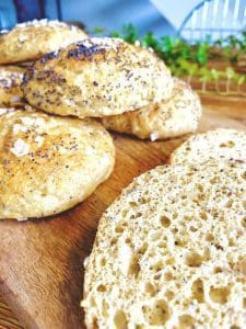 Färska bröd med vallmofrön och havssalt på en träskärbräda.