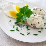 Två portioner matjesmousse på en tallrik med ägg och gräslök.
