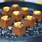 En tallrik med bitar av pepparkaksfudge dekorerade med apelsinskal.