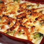 En ugnsgratäng med kassler och broccoli, täckt med smält ost i en röd form.