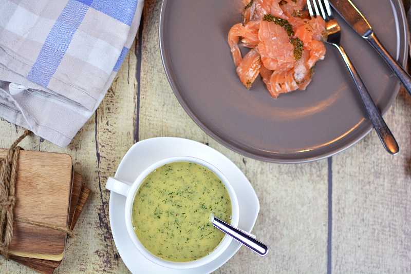 Hovmästarsås 7 En tallrik med gravad lax sedd uppifrån med en skål med hovmästarsås bredvid.