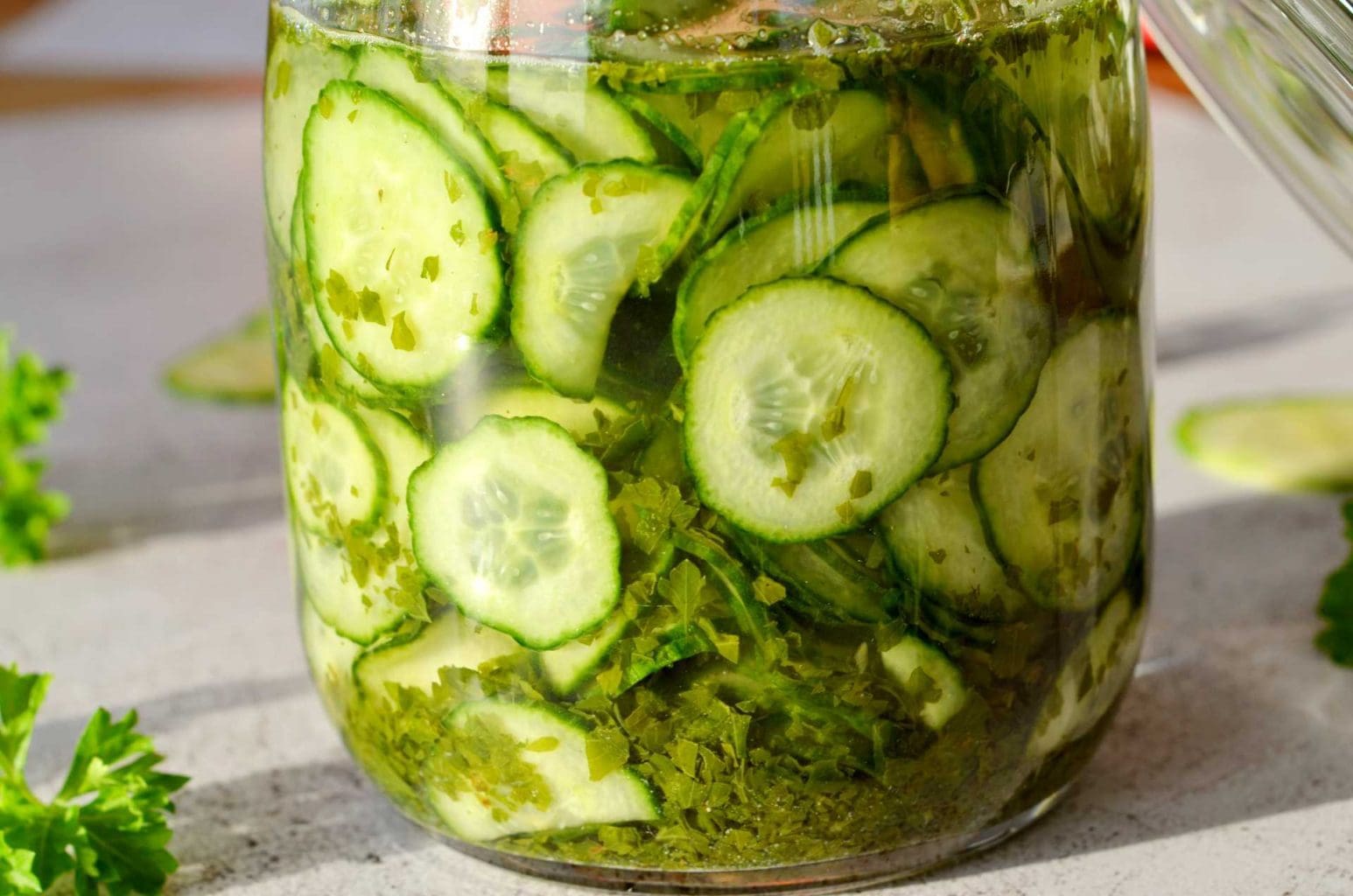 Picklad rödlök (utan socker) 15 En glasburk med skivade gurkor och grönsaker inlagda i en vätska.
