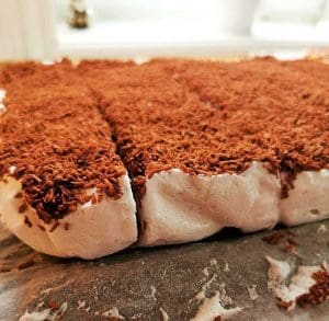 En bit LCHF mums mums med chokladströssel på toppen, skuren i portioner.