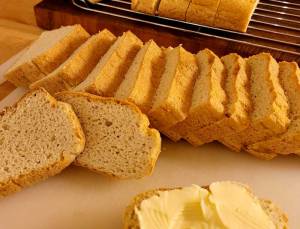 Skivor av lchf-bröd som ligger på en skärbräda med smör på en skiva.