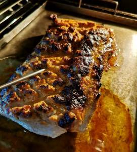 Helstekt fläskytterfilé med en gyllenbrun yta på en plåt, med kötttermometer insatt.
