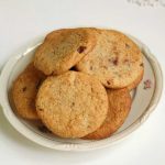 En tallrik med chokladchip-kakor som ligger staplade på varandra.