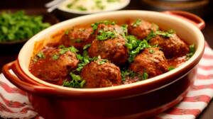 En skål med marockanska köttbullar i tomatsås, garnerad med färsk koriander.