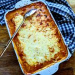 En gratinerad fläskytterfilé i en vit ugnsform med tomatsås och ost.