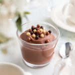 En skål med chokladmousse toppad med färgglada godisbitar i olika storlekar.