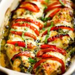 Ugnsbakad kycklingfilé med mozzarella, tomater och örter i en ugnsform.