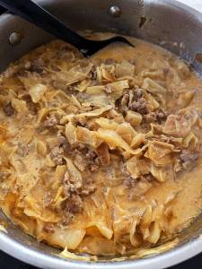 Kål- och köttgryta med köttfärs och grädde i en kastrull.